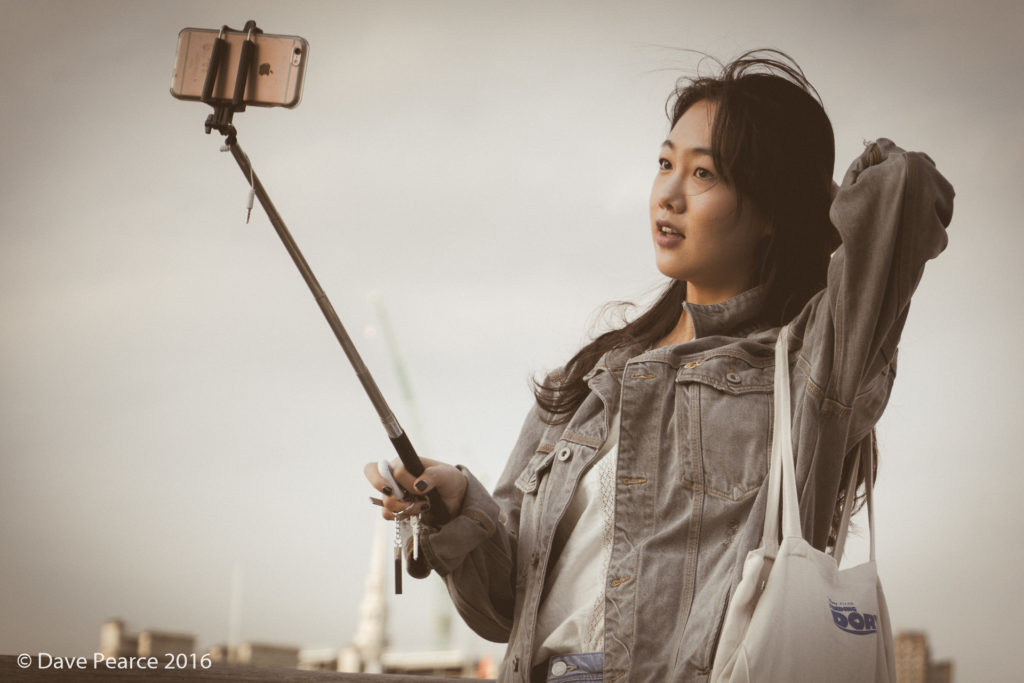 Una chica toma un selfie mientras camina.